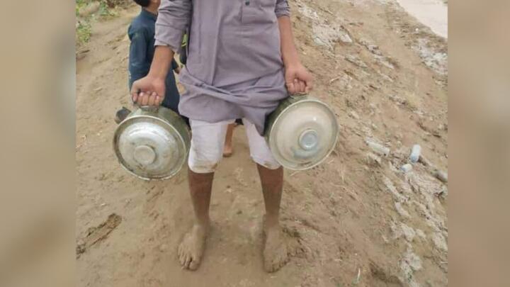 A local man holds up two anti-tank mines that he discovered after an intense rain storm in Marib, Yemen on July 31, 2022.